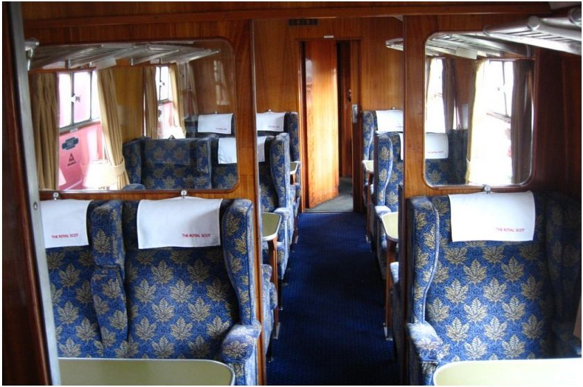 Modern First Class carriage with blue patterned seats and wood panelling